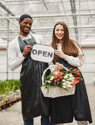 Employees with We Are Open Sign