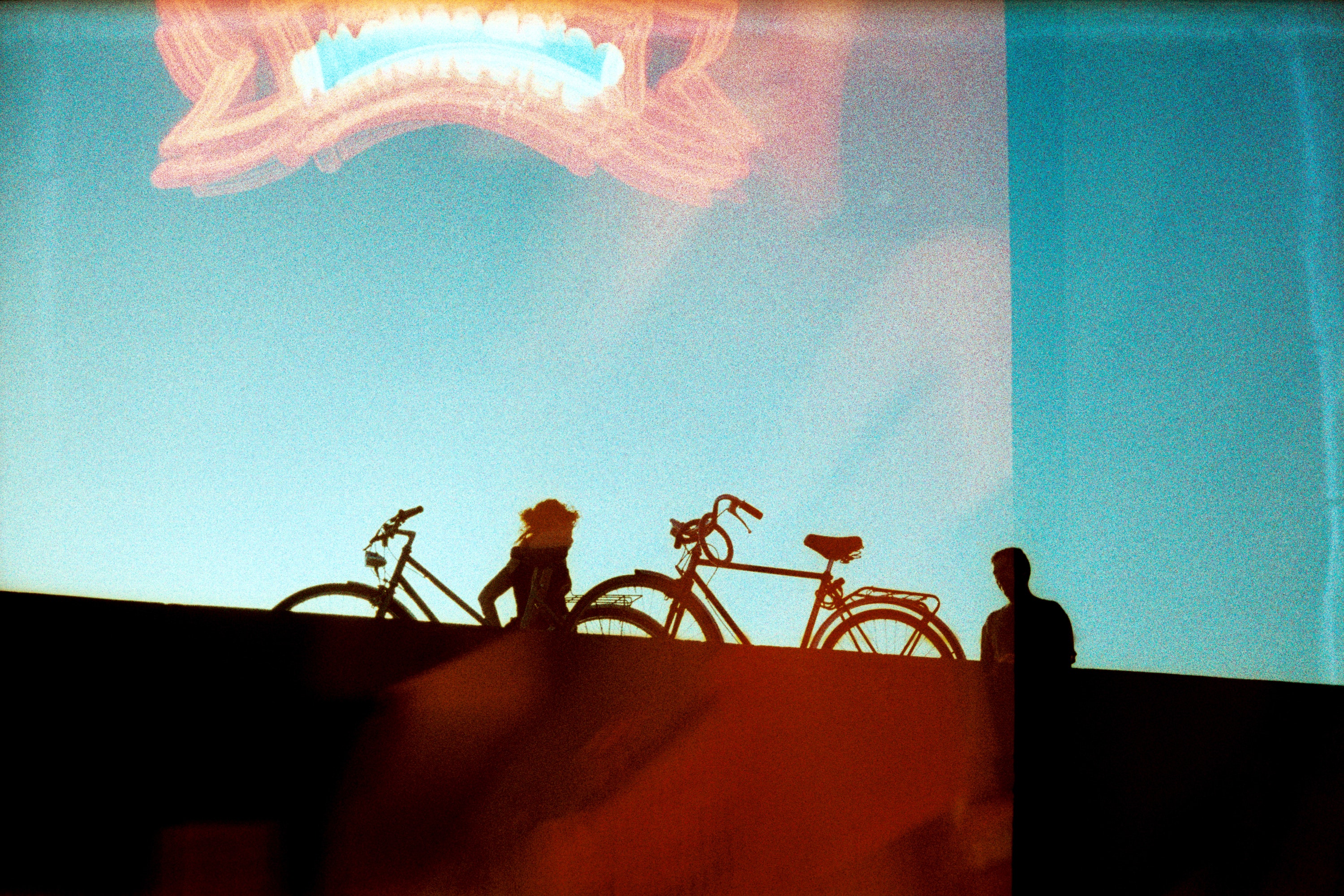 two people on a bridge holding bikes