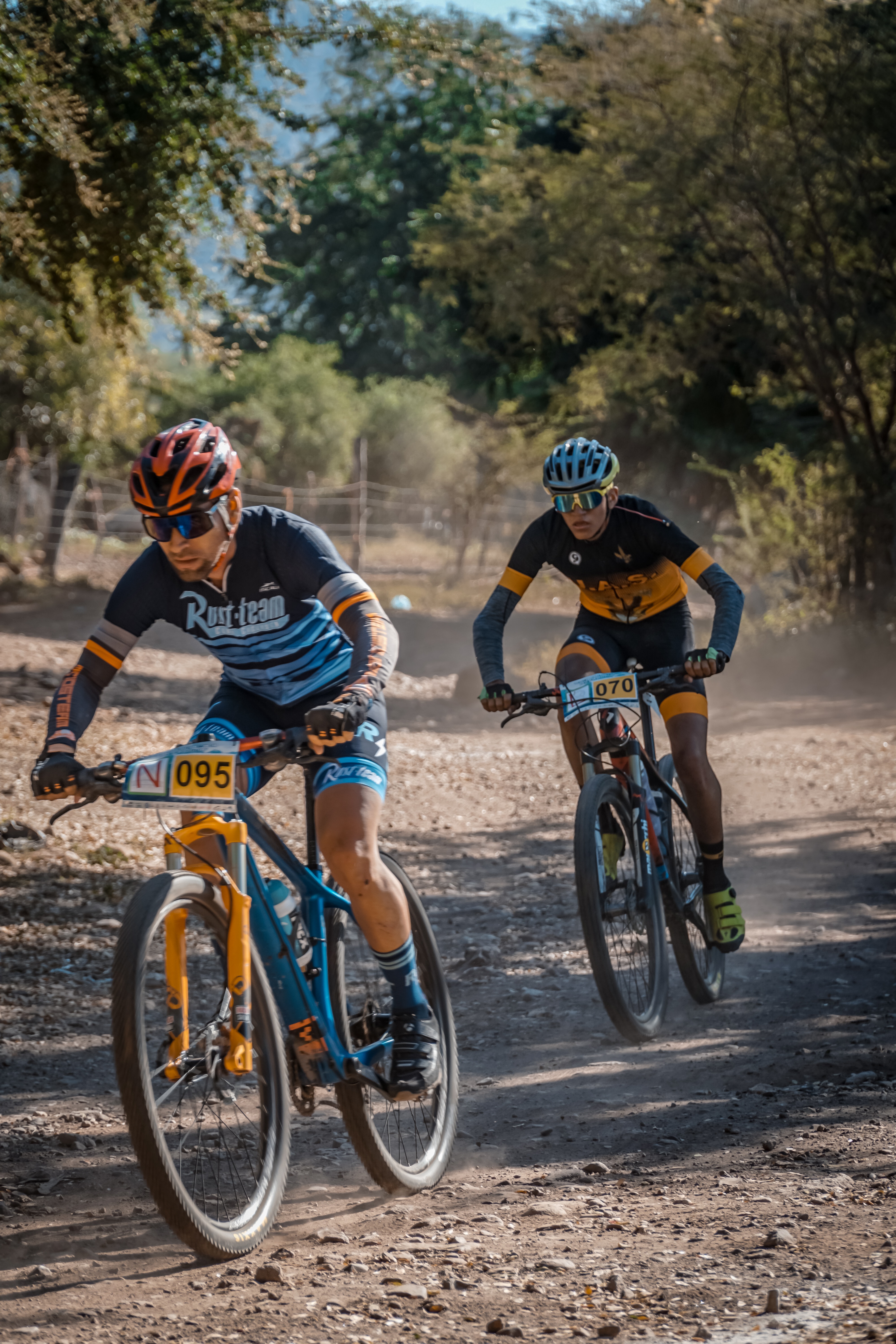 Three men riding bikes on a dirt road