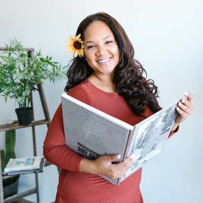 Oasis Book speaker Christina Peters in coral-colored dress holding book