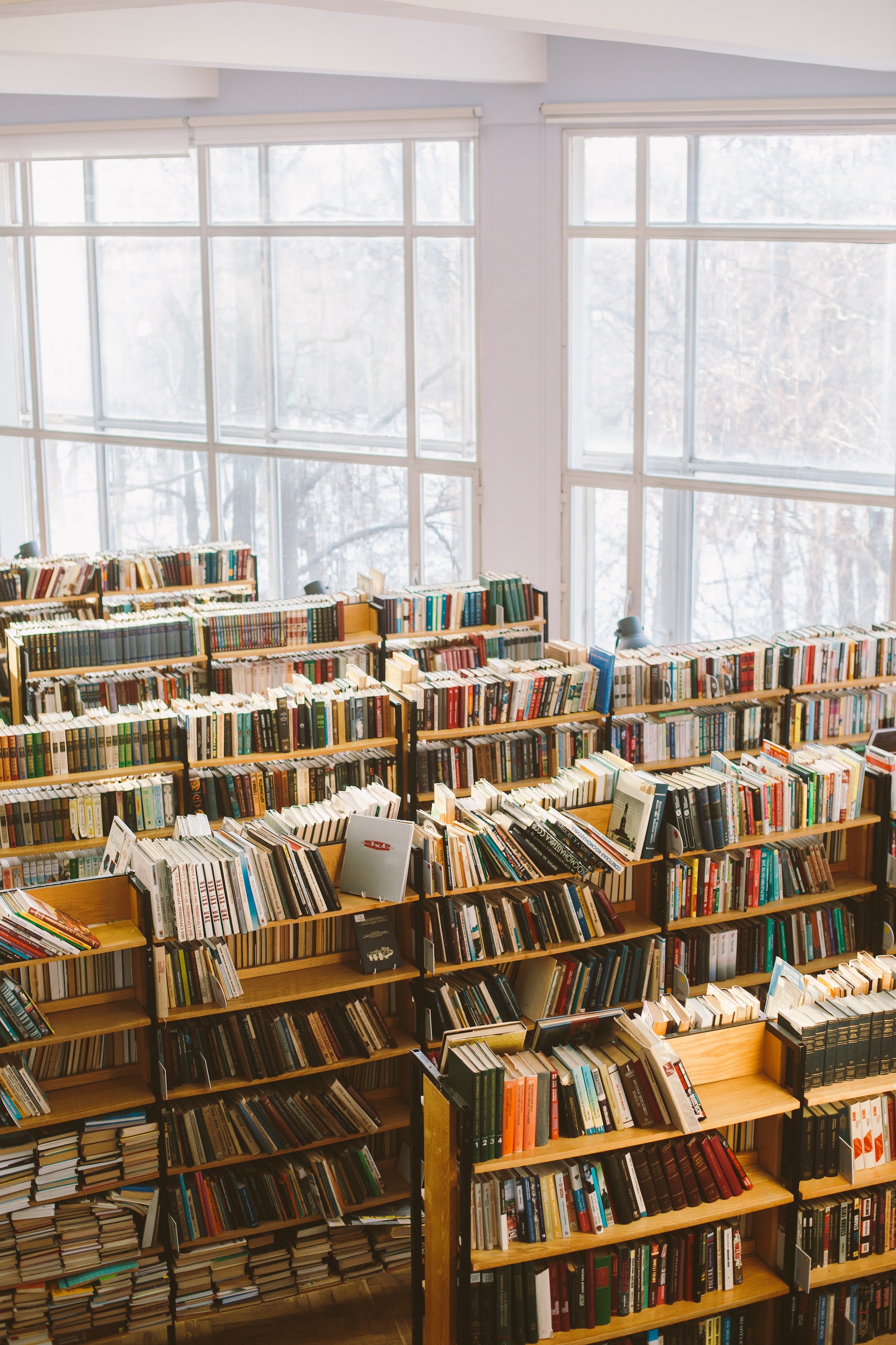 Picture of a public library with multiple shelves full of books.