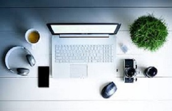 a picture include laptop, camera, head phones,mug of coffe