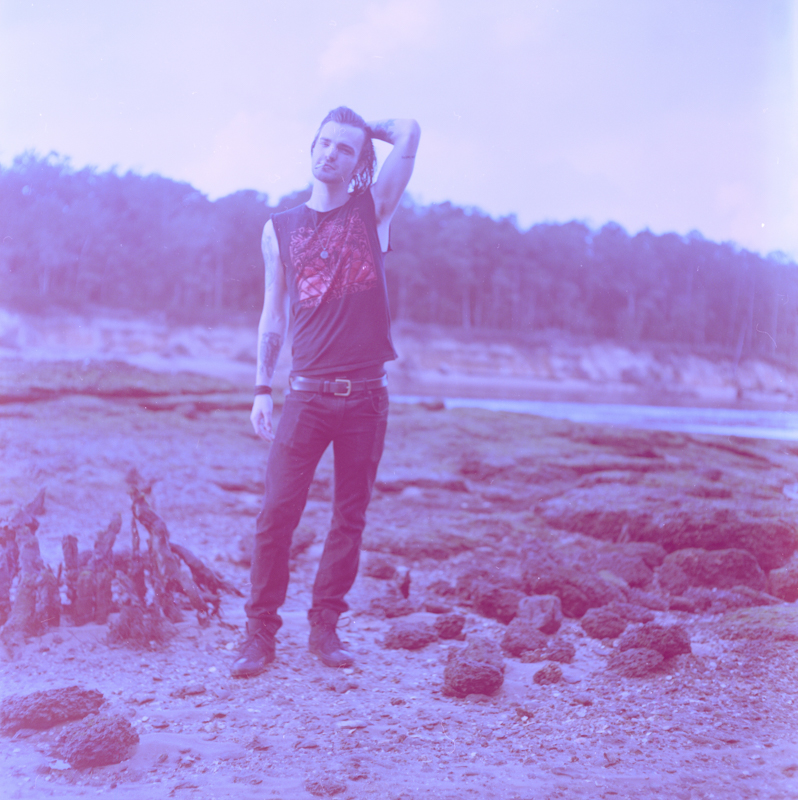 an abstract photographic portiat of a young man with a face that has been obscured with flowers 