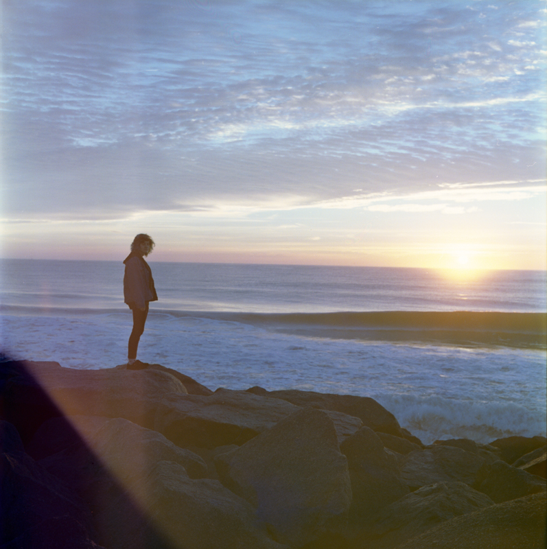 an abstract photographic portiat of a young man with a face that has been obscured with flowers 