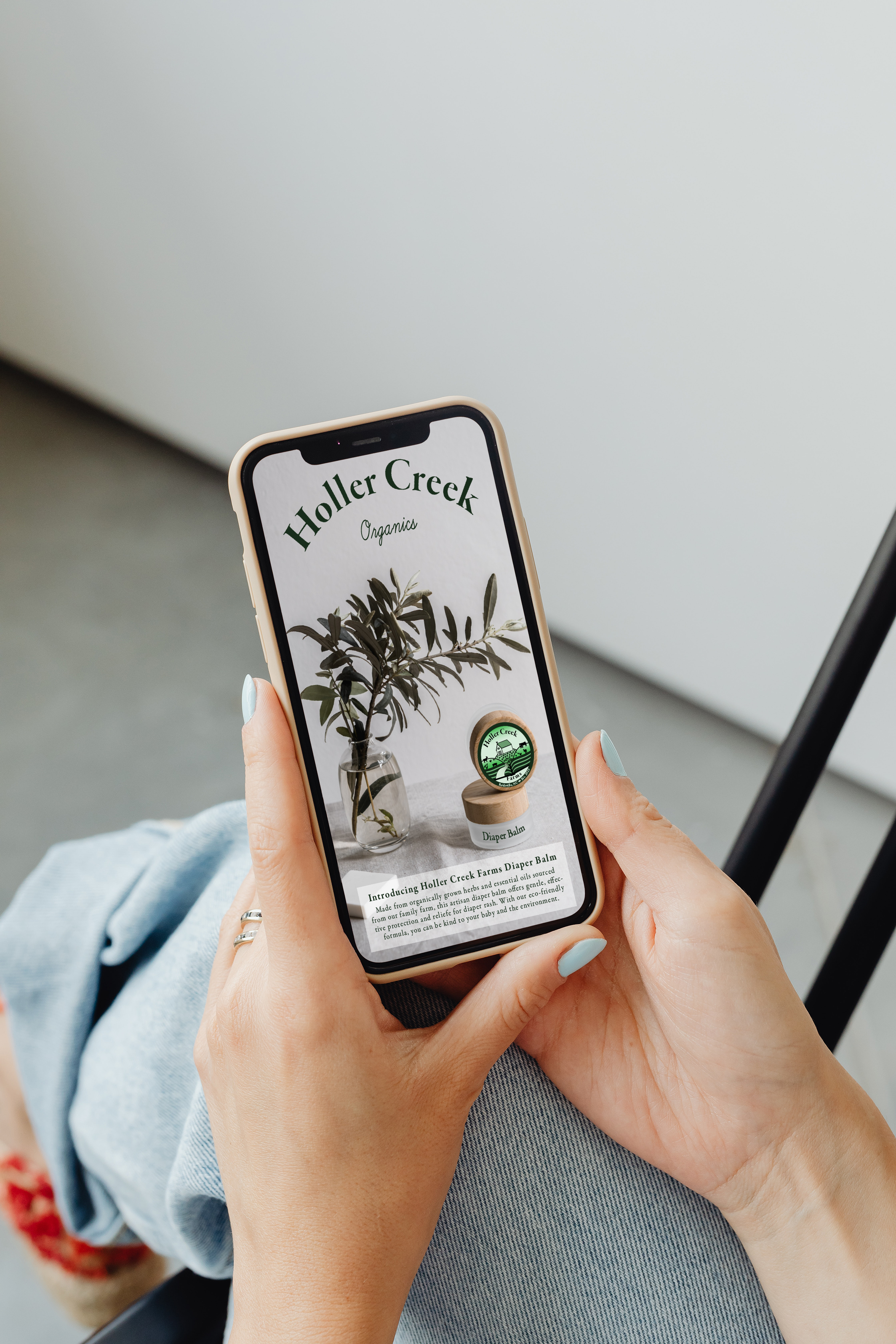 Phone displaying Holler Creek Farm Social Media story with picture of diaper balm on a tan tablecloth next to a plant