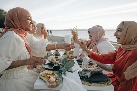 group of muslims ladies at a dinning table on beach