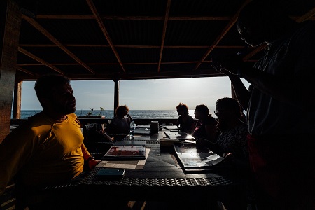 people dinning at a club with the beach in view