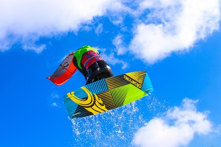 person kiteboarding on ocean up in the air