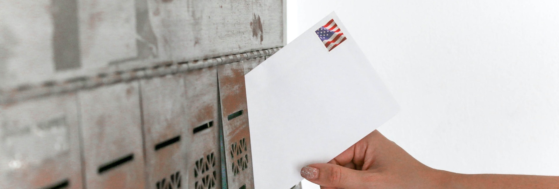 hand putting mail in mail box