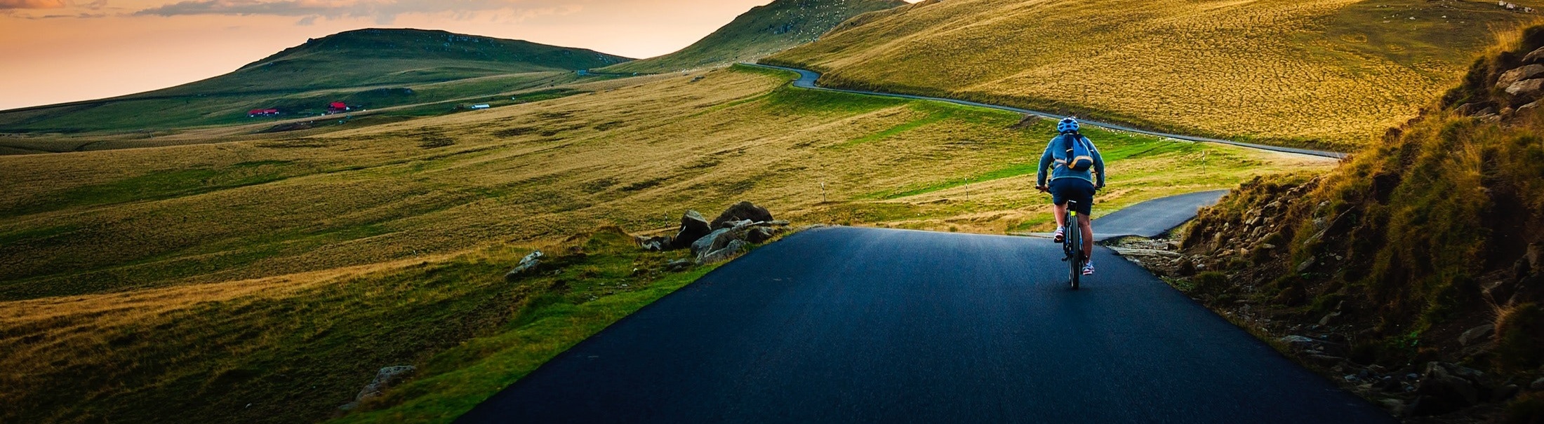 personn going down a green hill on a road