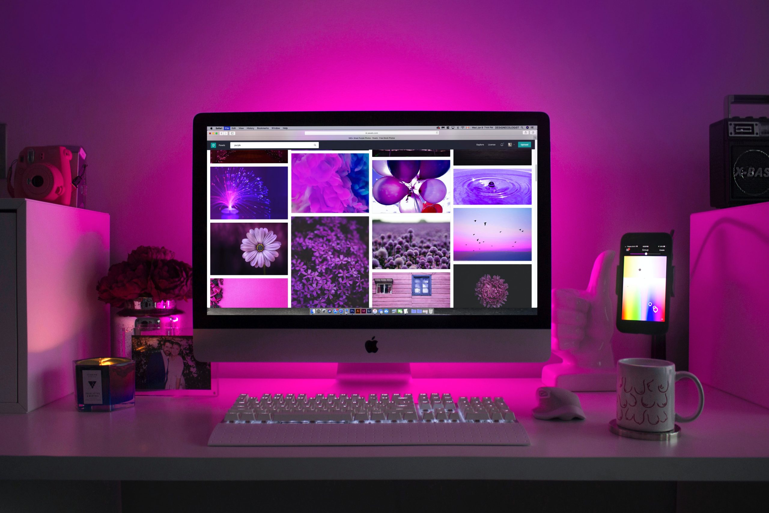 Image of pictures on computer monitor sitting on desk with purple light.