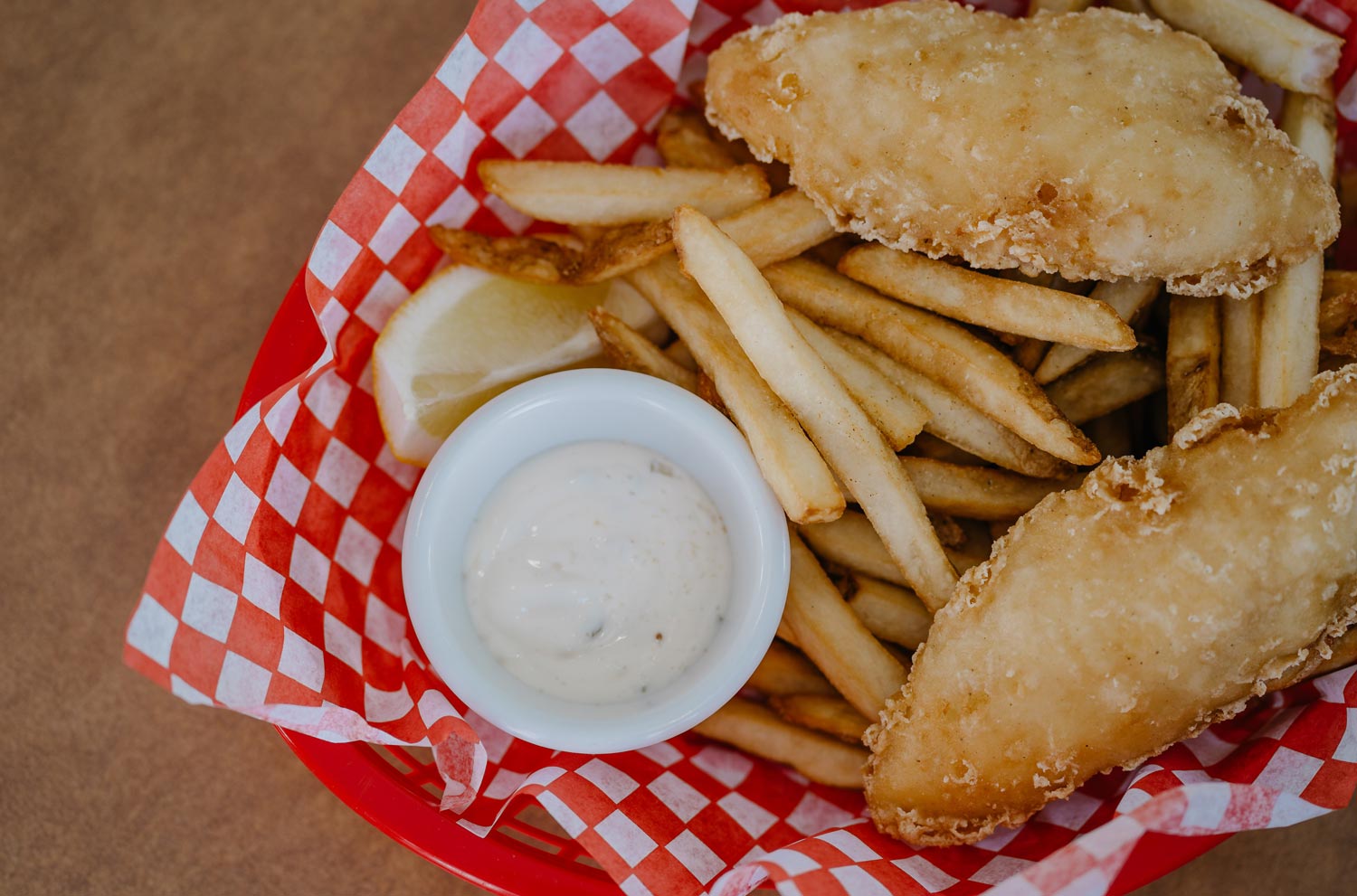 Fried fish and french fries on red and white checkered paper