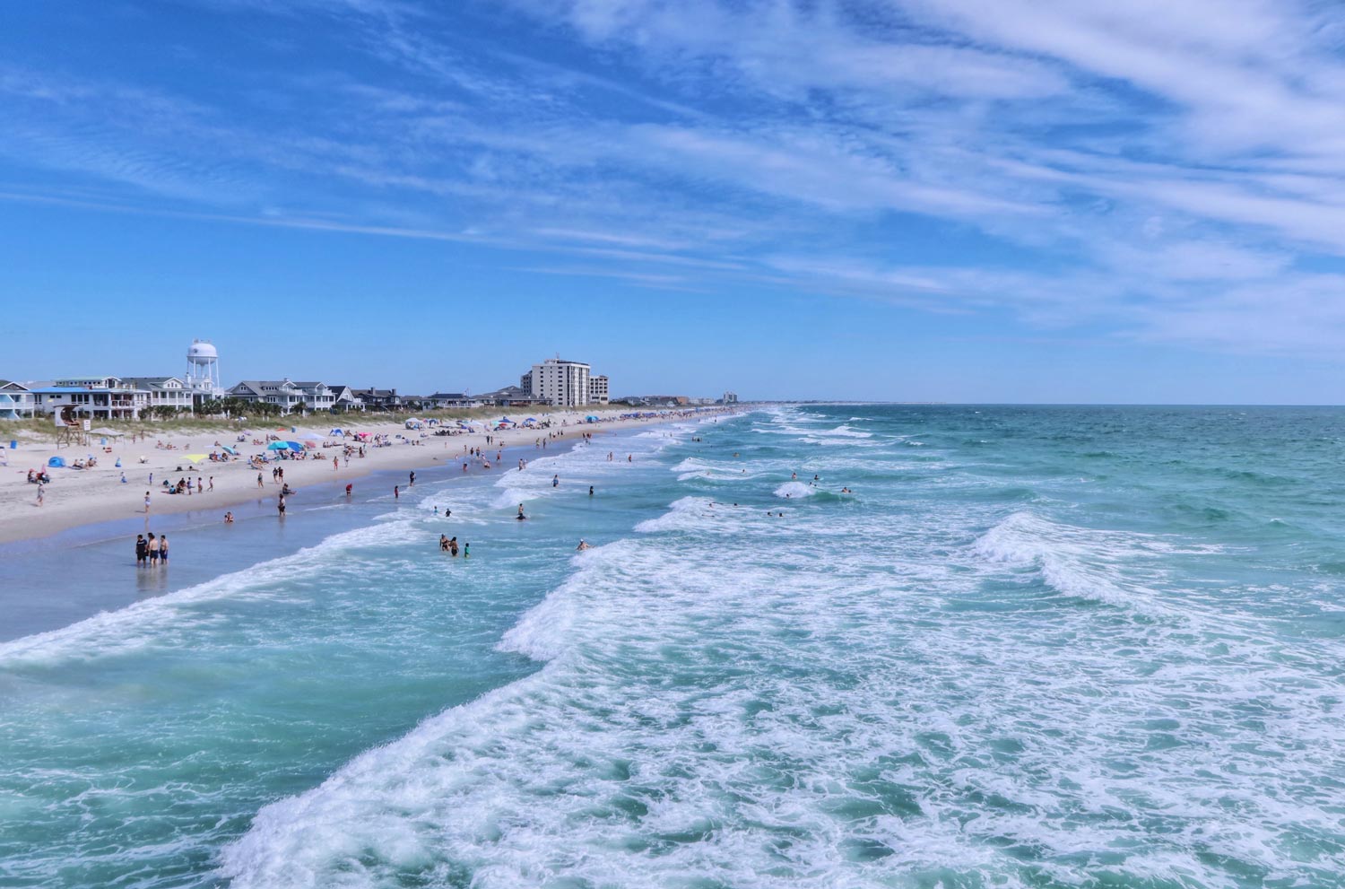 A view of the beach from above, with hotels along the horizon