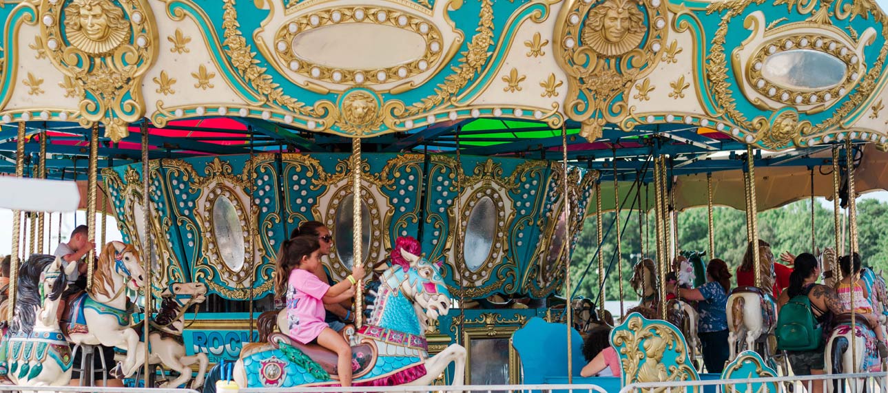 Adults and children riding on an old-fashioned, colorful carousel