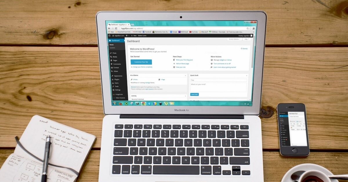 Laptop on desk with coffee and notepad