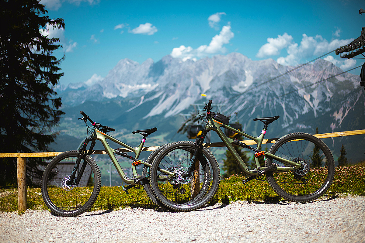 pair of 2 bicycles parked beside the wooden fence
