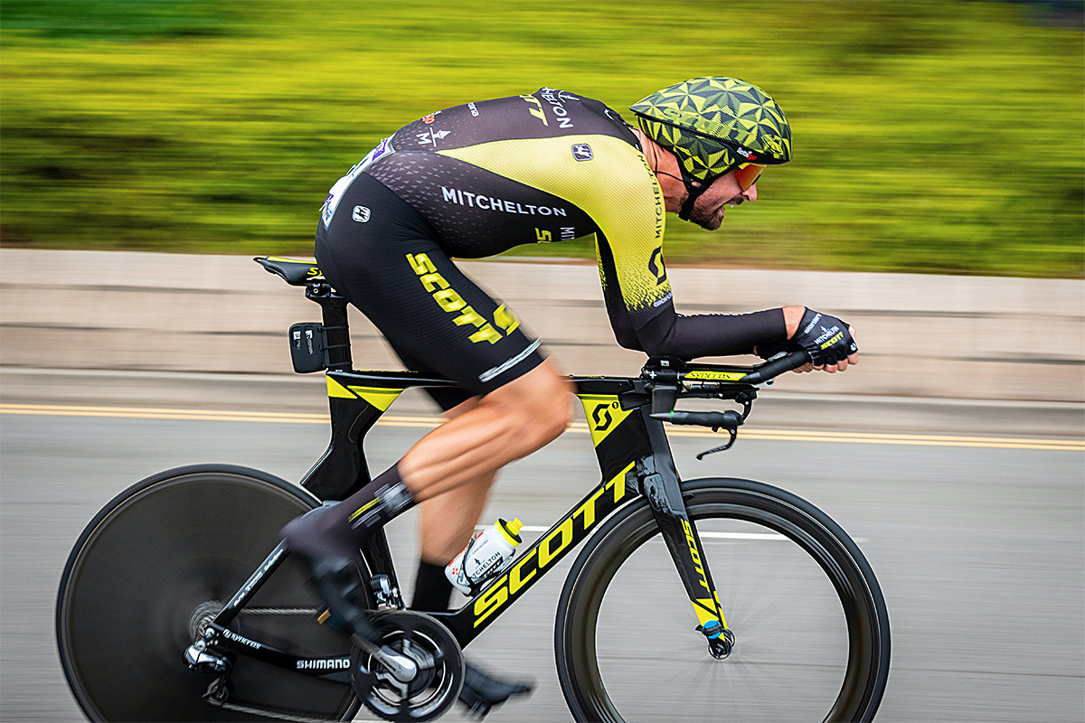 man racing with a bicycle in a bright yellow-green sport outfit